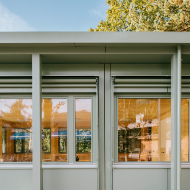 Part of the light-green pavilion facade with windows