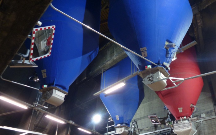 One red and three blue round indoor silos inside a building